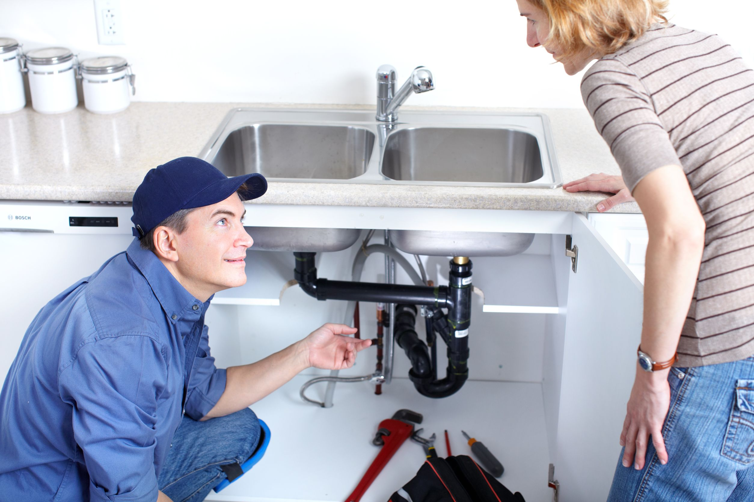 Dallas plumber explaining a kitchen sink repair to a homeowner